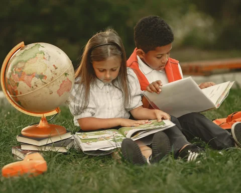 Two children reading on the grass