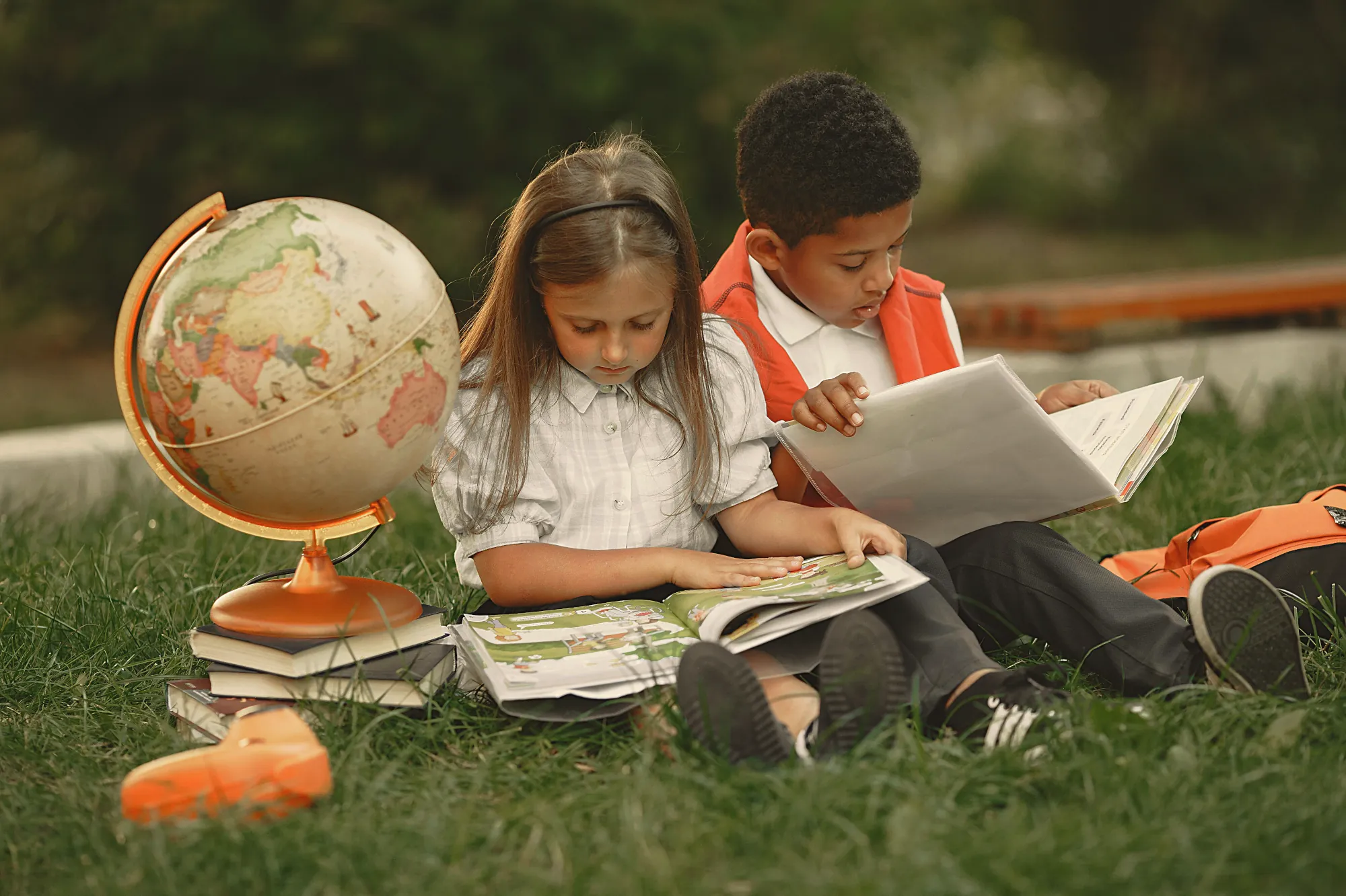 Two children reading on the grass