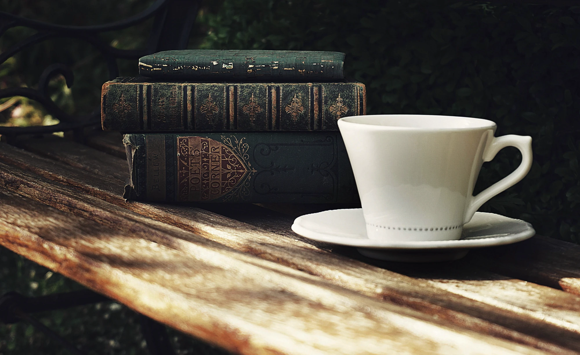 book stack on a bench with a cup of coffee