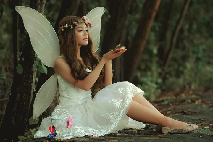 A fairy child in a wood with butterflies