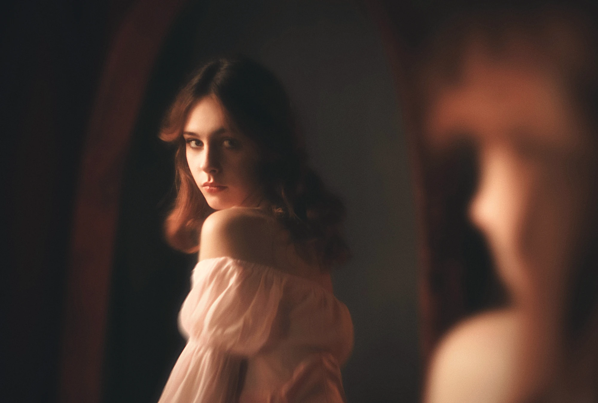 two women looking at each other through a mirror